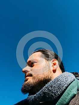 Bearded hipster man with long hair portrait. Perspective from below. Grainy retro vintage analog film effect and look concept