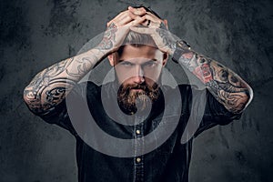 Bearded hipster with tattooe on his arms.