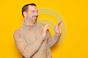 Bearded hispanic man in a turtleneck ducking to the side in embarrassment, tries to push away from something or someone