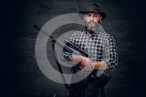 Bearded hunter holds a rifle.