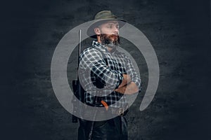 Bearded hunter holds a rifle.