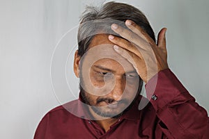 Bearded Indian man worried about white hair and hair loss at a young age
