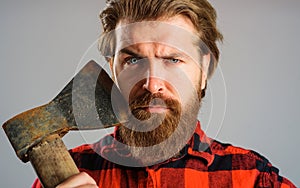 Bearded lumberjack with axe. Serious man in checkered shirt with old ax. Cutting wood. Sharp blade.