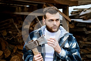 Bearded lumberjack checkered clothes carry axe. Sharp blade. Brutal man collects firewood. Hipster lifestyle