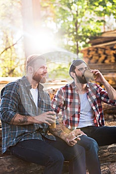 bearded lumberjacks with smartphone drinking coffee from papers cups