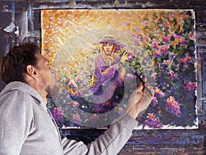 Bearded male artist and his painting on canvas