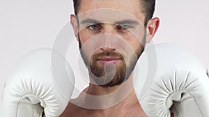 Bearded male boxer smiling to the camera, standing in fighting stance