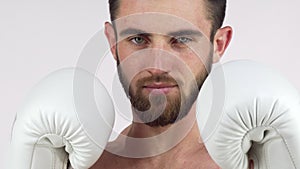 Bearded male boxer smiling to the camera, standing in fighting stance
