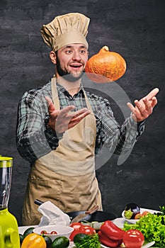 Bearded male chef cook holds pumpkin.