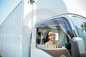 bearded male delivery man in uniform sitting smiling before leaving