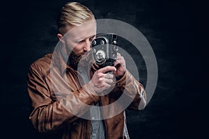 Bearded male holds the old 8mm video camera.