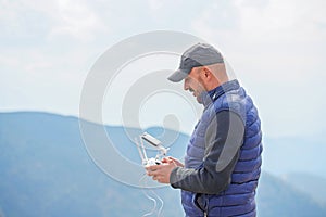 Bearded male model use drone remote control to fly device in air. Man operating drone flying in nature. New technologies