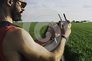 Bearded male model use drone remote control to fly device in air. Man operating drone flying in nature. New technologies