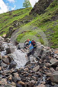 Bearded man adventurer with backpack is preparing to jump over a