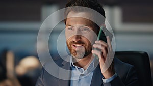 Bearded man answering call at night corporate office closeup. Man talking phone