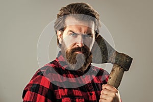 bearded man with axe. cut hair with ax. male hairdresser or barbershop. brutal butcher in shirt. lumberjack ready to