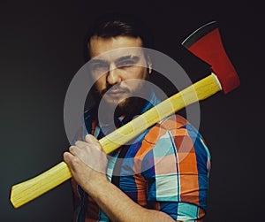 Bearded man with axe posing over black background in studio
