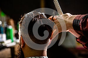 Bearded man in barber shop. Work in the barber shop. Man hairstylist. Hairdresser cutting hair of male client. Man