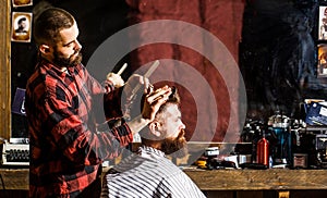 Bearded man in barbershop. Work in the barber shop. Hairdresser cutting hair of male client. Hairstylist serving client