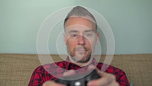 Bearded man blankly playing a video game