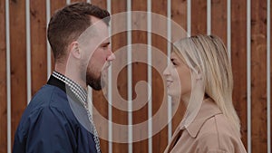 Bearded man and blonde woman are looking to each other and talking synchrony