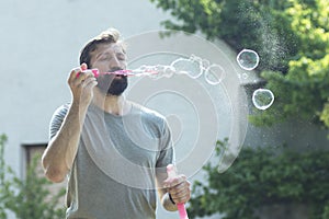 Bearded man blowing soap bubbles