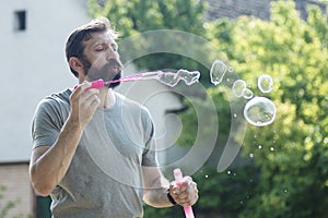 Bearded man blowing soap bubbles