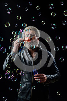 Bearded man blowing Soap bubbles. Play with inflate bubbles. Happiness. Good mood. Childhood.