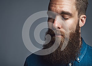 Bearded man in blue denim with eyes closed
