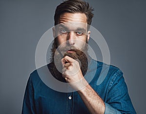 Bearded man in blue denim with serious expression