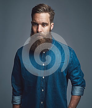 Bearded man in blue denim with serious expression