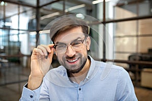 Bearded man in a blue shirt wearing eyeglasses