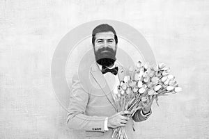 Bearded man in bow tie with tulip flowers. bride groom at wedding party. spring bouquet. 8 of march. love date with