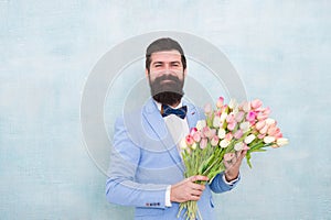 Bearded man in bow tie with tulip flowers. bride groom at wedding party. spring bouquet. 8 of march. love date with