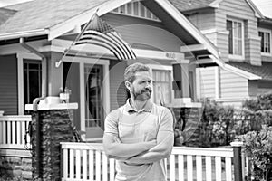 bearded man broker selling or renting house with american flag, home