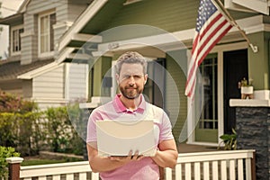 bearded man broker selling or renting house with american flag on pc online, home