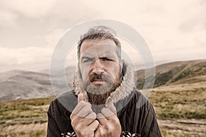 Bearded man, brutal caucasian hipster with moustache cold on mountain