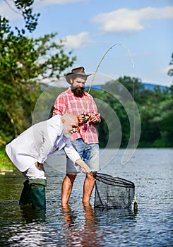 Bearded man and brutal hipster fishing. Family day. Fishing team. Peace of mind and tranquility. Freshwater fish. Active