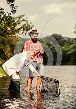 Bearded man and brutal hipster fishing. Family day. Fishing team. Peace of mind and tranquility. Freshwater fish. Active