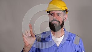 Bearded man builder in helmet ready to write something by finger