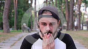 Bearded man closing eyes with hand showing stop gesture, confused to watch.