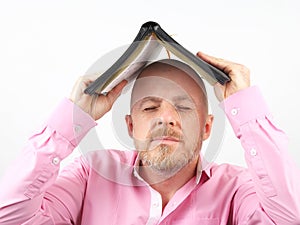 Bearded man covers his head with an open Bible