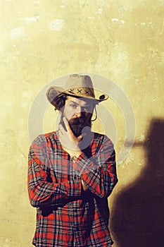 Bearded man in cowboy hat and black shadow on wall