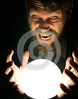 Bearded man in the dark, holding in front of a lamp, expresses different emotions