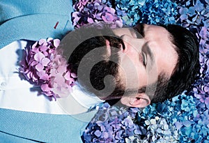 A bearded man with a decorated beard for the Spring holiday. Flower in the beard. Bearded man with beard in flover in