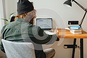 Bearded man doing home work while studying at university