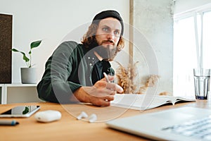 Bearded man doing home work while studying at university