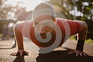 Bearded man doing push ups in the outdoor gym