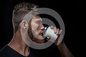 Bearded man drinking coffee on the go