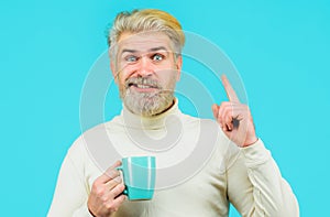Bearded man drinking hot coffee or tea. Fashionable man with stylish hair with cup warm beverage.